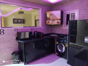 lavadero púrpura con lavadora y secadora en Hi Pyramids, en El Cairo