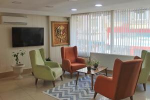 une salle d'attente avec des chaises et une télévision à écran plat dans l'établissement EViM HOTEL, à Çorlu