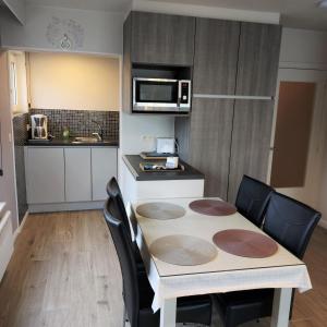 a kitchen with a table and chairs in a room at Studio ABI in Oostduinkerke