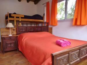 a bedroom with a bed with a pink stuffed animal on it at Casa La Toma in Capilla del Monte