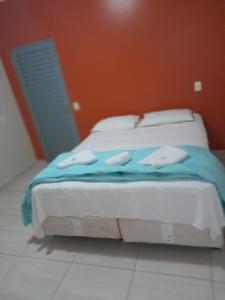 Una cama con una manta azul en una habitación en Pousada Casebre, en Pirenópolis