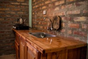 a kitchen counter with a sink and a brick wall at Cabañas de la bodega Romano-Pin in Albardón +17 photos