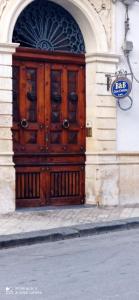 una gran puerta de madera en el lateral de un edificio en Casa Cristina, en Siracusa