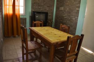 a dining room with a wooden table and chairs at Cabañas de la bodega Romano-Pin in Albardón