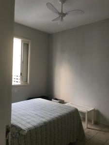 a bedroom with a bed and a ceiling fan at Ap frente ao mar in Sao Paulo
