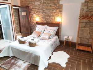 a bedroom with a bed and a stone wall at La Petite Coquille in LʼOrbrie