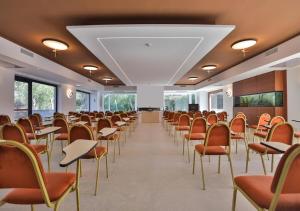 an empty room with chairs and tables and a podium at Hotel Hermitage in Galatina +58 photos
