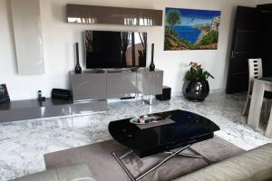 a living room with a tv and a table at Penthouses+Terrasse 60 m2+Box 2 Vehicules in Beausoleil