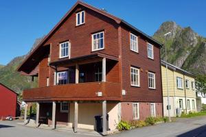 a large wooden house with a mountain in the background at Koselig hus i havna in Svolvær