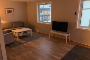 a living room with a couch and a flat screen tv at Koselig hus i havna in Svolvær