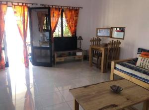 a living room with a tv and a table at La Maison Aziz - Somone - Sénégal in Somone