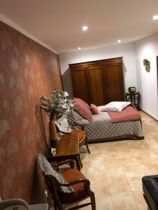 een slaapkamer met een bed en een tafel en stoelen bij Coquet T2 au coeur du village in Sartène