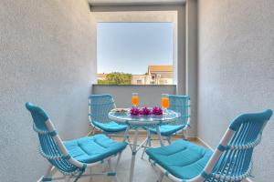 un tavolo con sedie e un balcone con bevande di Apartmani Kaštelina a Vir (Puntadura)
