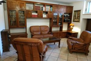 een woonkamer met lederen stoelen en een salontafel bij Camera confortevole tra Roma e Ostia in Acilia