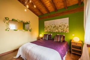 ein Schlafzimmer mit einem Bett und einem Wandgemälde in der Unterkunft CASUCAS LA GUARIZA (Casa Eva ) in Fontibre