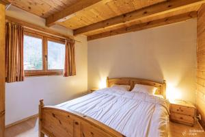 een slaapkamer met een houten bed in een kamer bij Chalet Val de l'Amblève in Sougné-Remouchamps