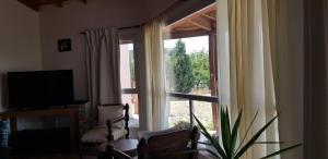 a living room with a large window and a television at APA Las Condalias in Puerto Madryn