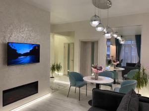 a living room with a fireplace and a tv on a wall at Panorama Luxury Apartment in The House with a Spire, a historical building in the city centre in Kharkiv