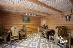 a dining room with a table and wooden walls at Садиба Припір in Abranka