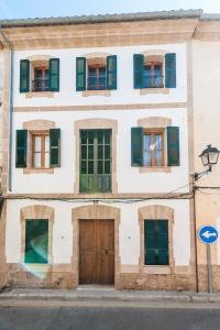 a building with green shuttered windows and a door at CA NA BLANCA in Alcudia