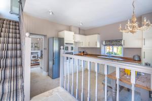 a kitchen with white cabinets and a blue refrigerator at Devonshire Cottage, in the heart of Broadway in Broadway