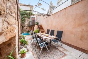 une terrasse avec une table, des chaises et une piscine dans l'établissement CA NA BLANCA, à Alcúdia