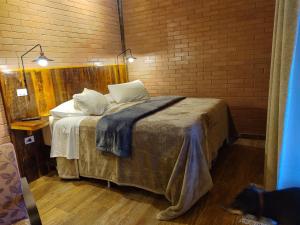 sypialnia z dużym łóżkiem w ceglanej ścianie w obiekcie Pousada Recanto Primavera w mieście Piedade