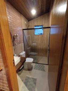 a bathroom with a shower and a toilet and a sink at Pousada Recanto Primavera in Piedade