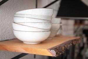 a group of white bowls sitting on a shelf at Sohana Lifestyle Apartments I Leilani's & Saskia's Home I Rust in Rust