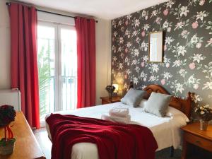 a bedroom with a bed with a floral wallpaper at Hostal Azahara in Nerja