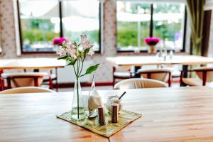a table with a vase with flowers on it at Villa Mariner in Mielno +63 photos