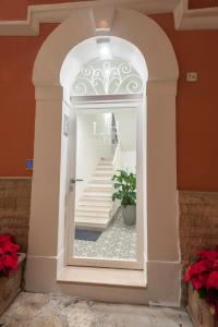 an archway with a reflection of a staircase in a mirror at Porta Piccola Luxury Home in Bari