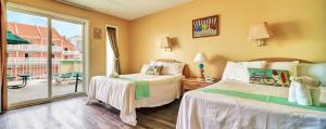 a bedroom with two beds and a balcony at Acacia Beachfront Resort in Wildwood Crest