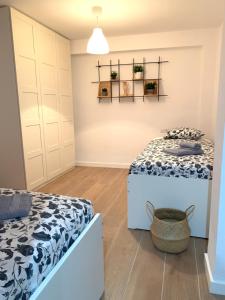 a bedroom with two beds and a basket on the floor at UIM Mediterraneo Buenavista Wifi in Puerto de Sagunto