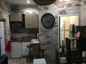 a kitchen with white cabinets and a brick wall at Chambre D'hôte Villa Maurice in Étretat