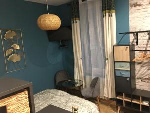 a bedroom with blue walls and a bed and a table at Chambre D'hôte Villa Maurice in Étretat