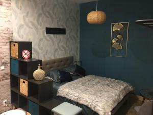 a bedroom with a bed and a blue wall at Chambre D'hôte Villa Maurice in Étretat