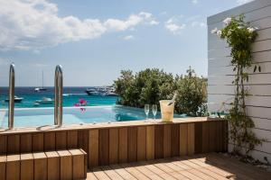 a swimming pool with a view of the ocean at Mykonos Dove Beachfront Hotel in Platis Gialos