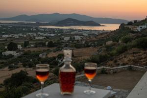 Alta Vista Naxos في ناكسوس تشورا: كأسين من النبيذ يجلسون على طاولة مع غروب الشمس