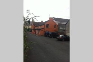 a street with cars parked in front of a house at Camp Street Studio Room 4 in Oughterard