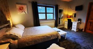 a bedroom with a bed and a desk and a window at Church View House in Gorteen