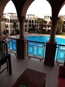 a view of a swimming pool from the balcony of a building at Gorgeous Pool View Apartment - Tala Bay Resort, Aqaba in Aqaba