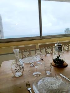 a wooden table with glasses and a bottle on it at Superbe appartement face à la mer avec parking privatif in Canet-en-Roussillon