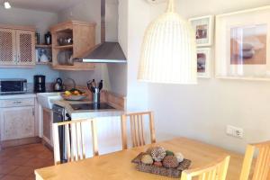 a kitchen with a wooden table and a dining room at Apartamento gran terraza privada y vistas al mar in Port de Soller