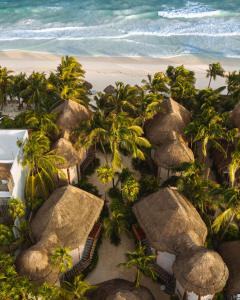an aerial view of a beach with palm trees and umbrellas at Encantada Tulum in Tulum