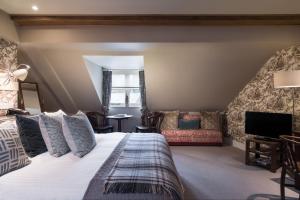 a bedroom with a large bed and a living room at The Howard Arms in Ilmington