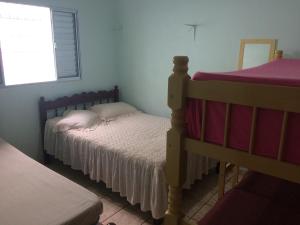 圣塞巴斯蒂安Casa com Amplo quintal no Canto do Mar的一间卧室，有两张双层床和一扇窗户