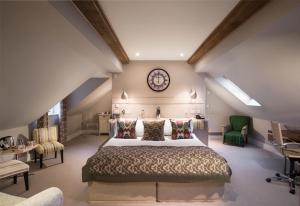 een slaapkamer met een groot bed en een klok aan de muur bij The Howard Arms in Ilmington