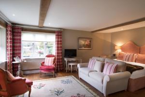 a living room with a white couch and a desk at The Howard Arms in Ilmington