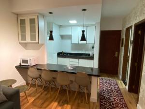 a kitchen with a counter and chairs in a room at Apartamento Campos do Jordao Home Green Home in Campos do Jordão